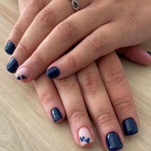Ongle avec vernis bleu sombre et coeurs